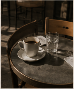 espresso cup and glass of water on a cafe table in afternoon light